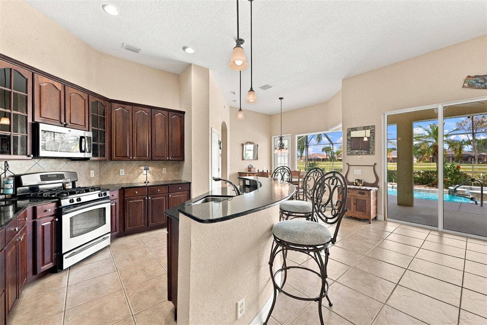 Beautiful dark cherry all wood cabinets are stunning against the softer paint tones on the walls and floors. Lots of room for multiple cooks along with plenty of cabinets and storage.  What a view to the outside!