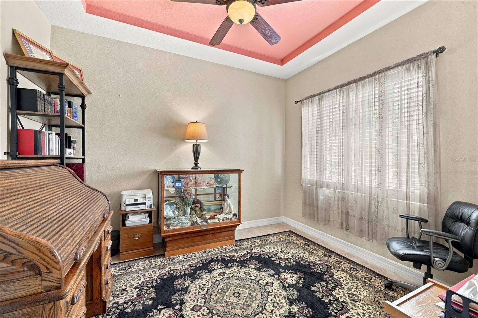 The room is bright and open with plantation shutters and a tray ceiling for elegance.
