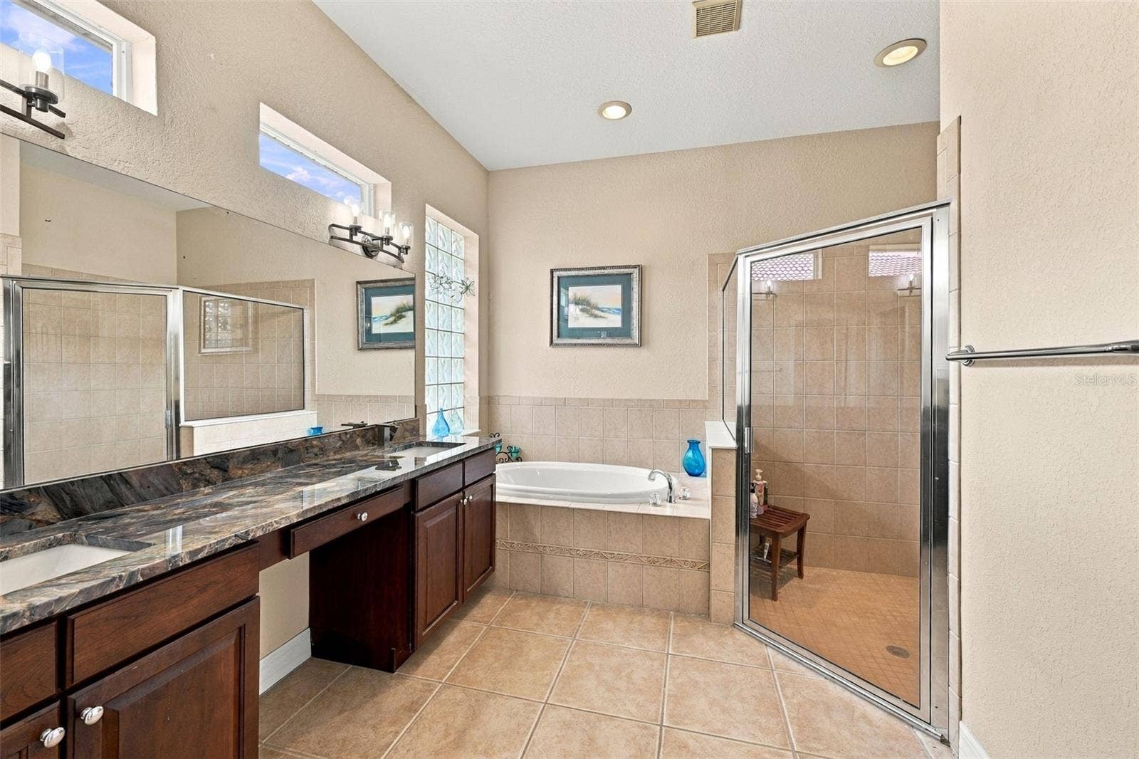 Beautifully updated bathroom, granite counters and soaking tub make this a perfect master bath.  Notice the multiple windows and it evens offers a private water closet.