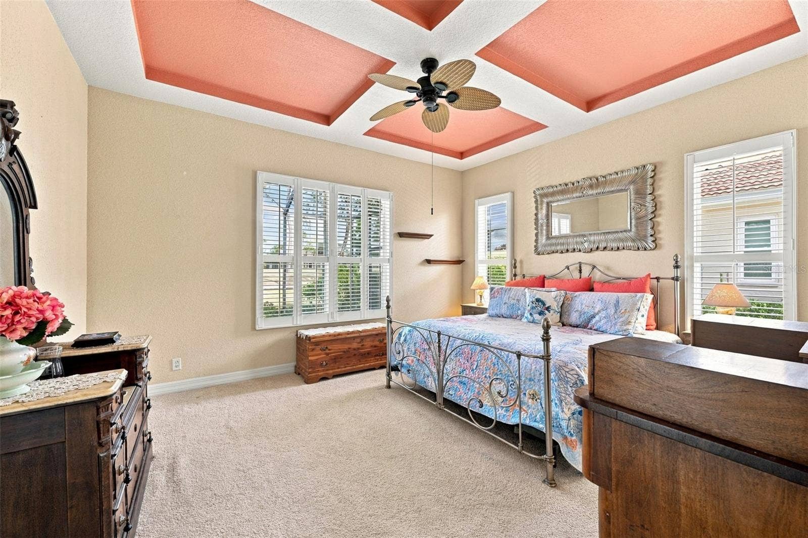 Primary bedroom is very spacious with a custom tray ceiling, multiple windows for lots of sunshine and plantation shutters.