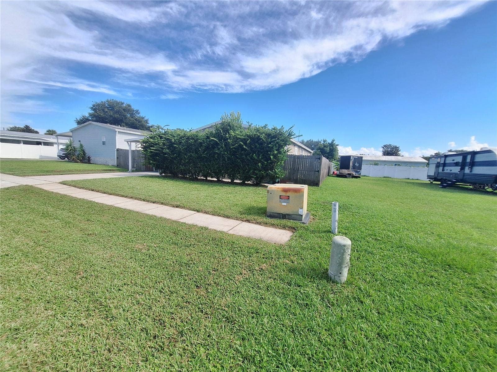 37650 NEWPORT DRIVE, Zephyrhills, FL 33542 Exterior showing privacy landscaping across the front.