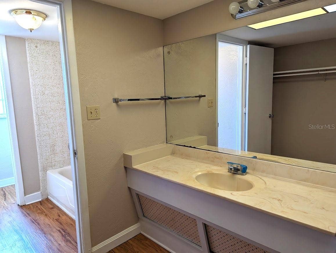 En suite bathroom with vanity, closet, tub shower and water closet