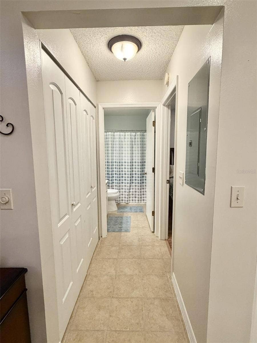 hallway with laundry, guest bedroom and bath