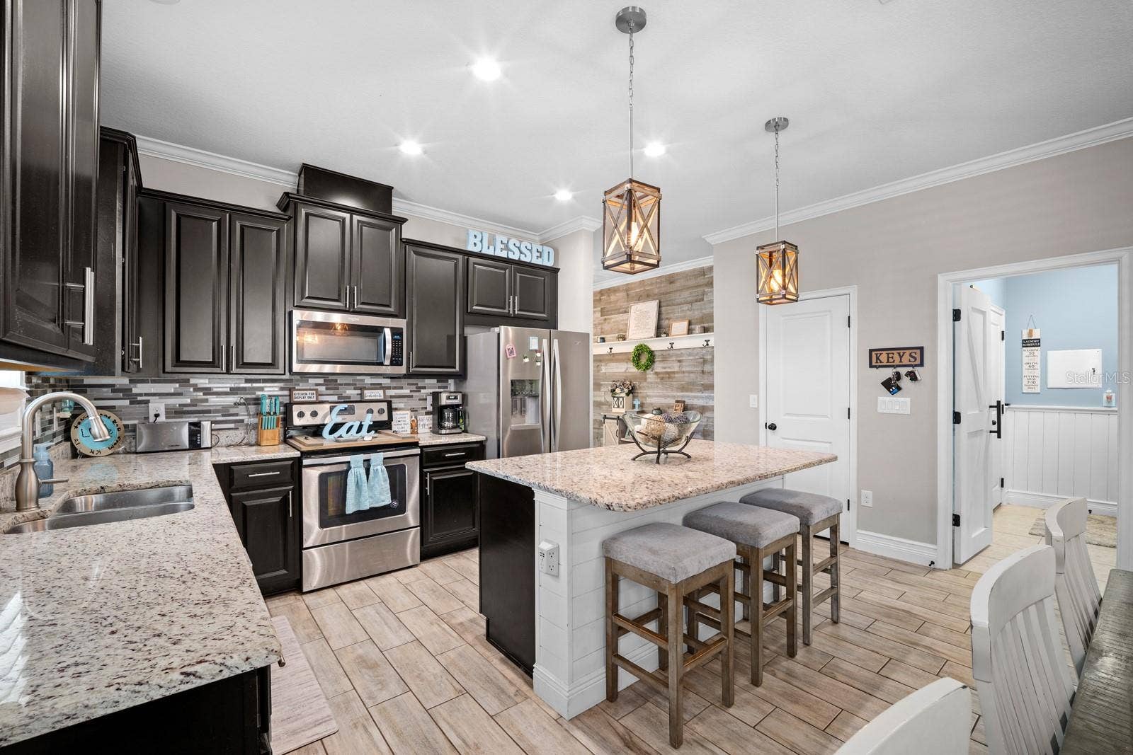 10654 PLANER PICKET DRIVE, Riverview, FL 33569 Wide view of the kitchen with espresso cabinets, tile backsplash and pendant lights