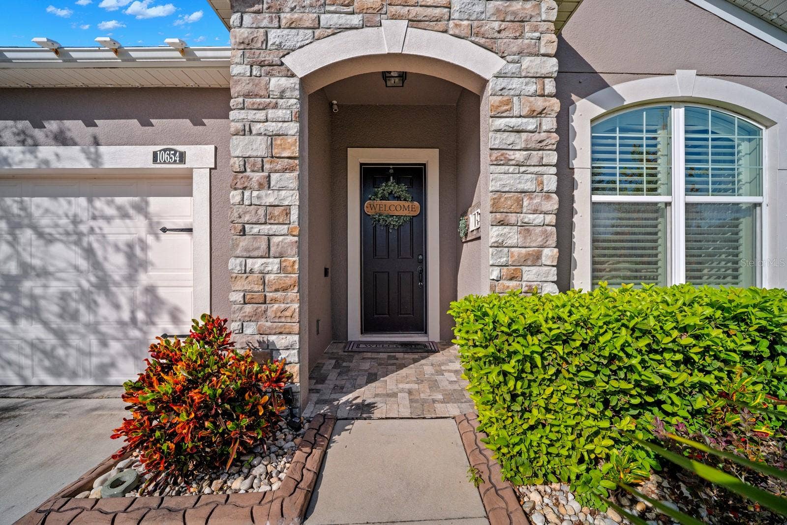 10654 PLANER PICKET DRIVE, Riverview, FL 33569 Covered front entry with stone columns and arched doorway