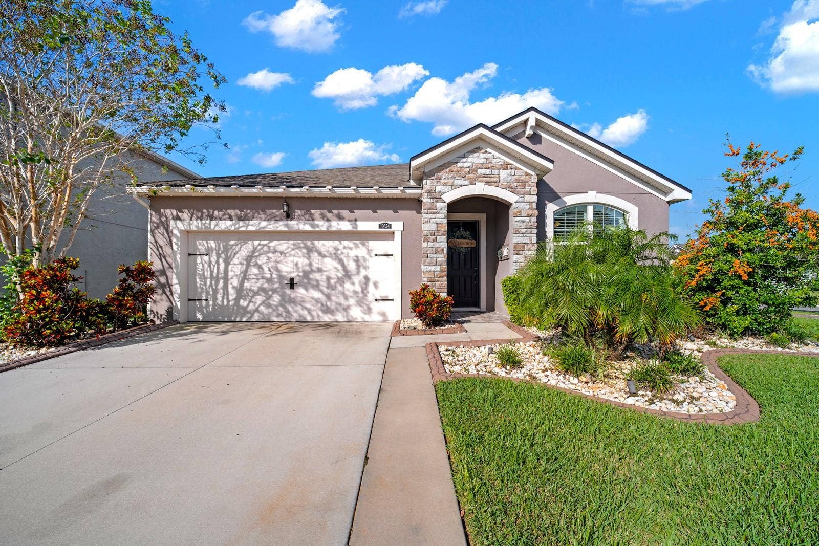 10654 PLANER PICKET DRIVE, Riverview, FL 33569 Front exterior with 2-car garage, stone accents and mature landscaping