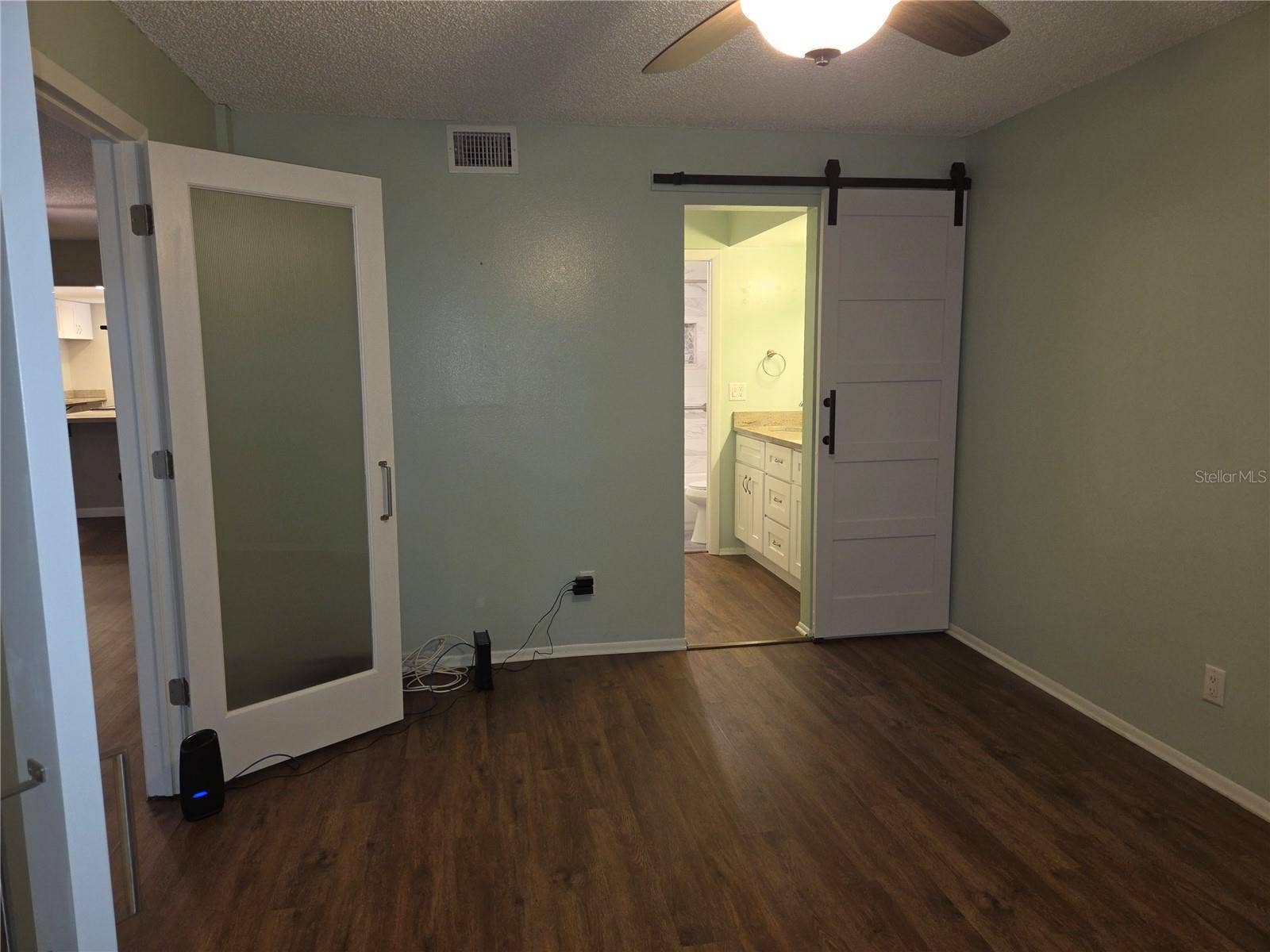5943 CALAIS BOULEVARD N, #6, St Petersburg, FL 33714 Entrance to ensuite bath from primary bedroom has a barn door.