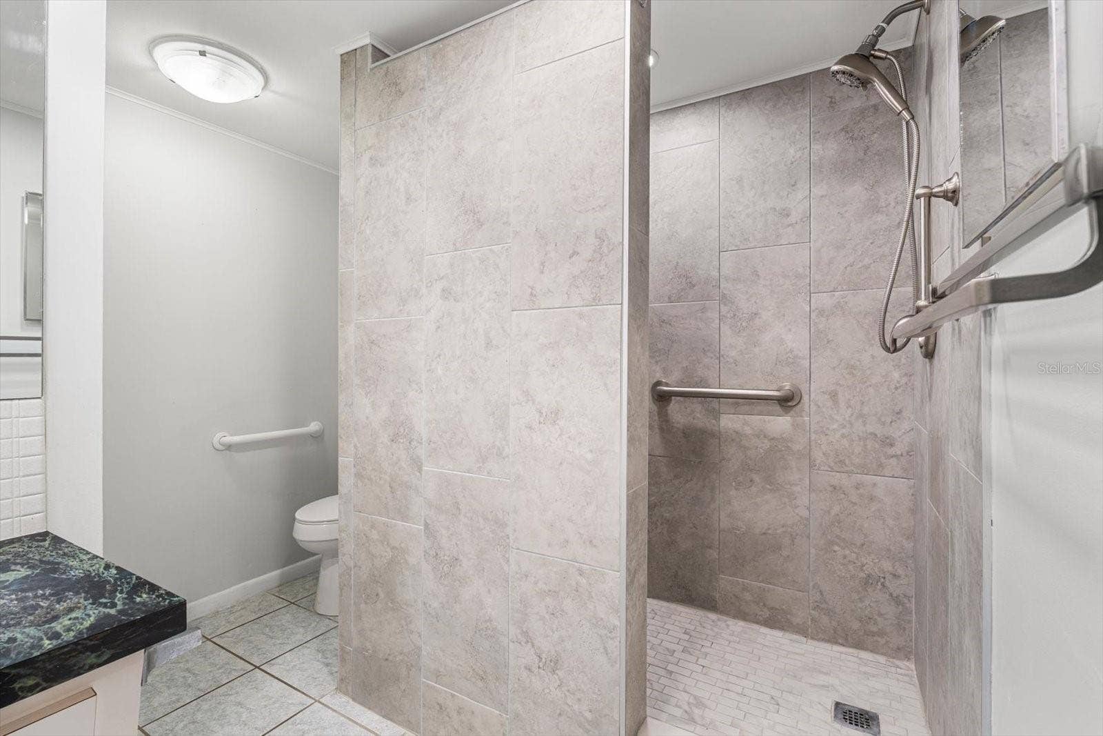 10351 REGAL DRIVE, #4, Largo, FL 33774 A large walk-in shower with a bench is featured in the primary bathroom.