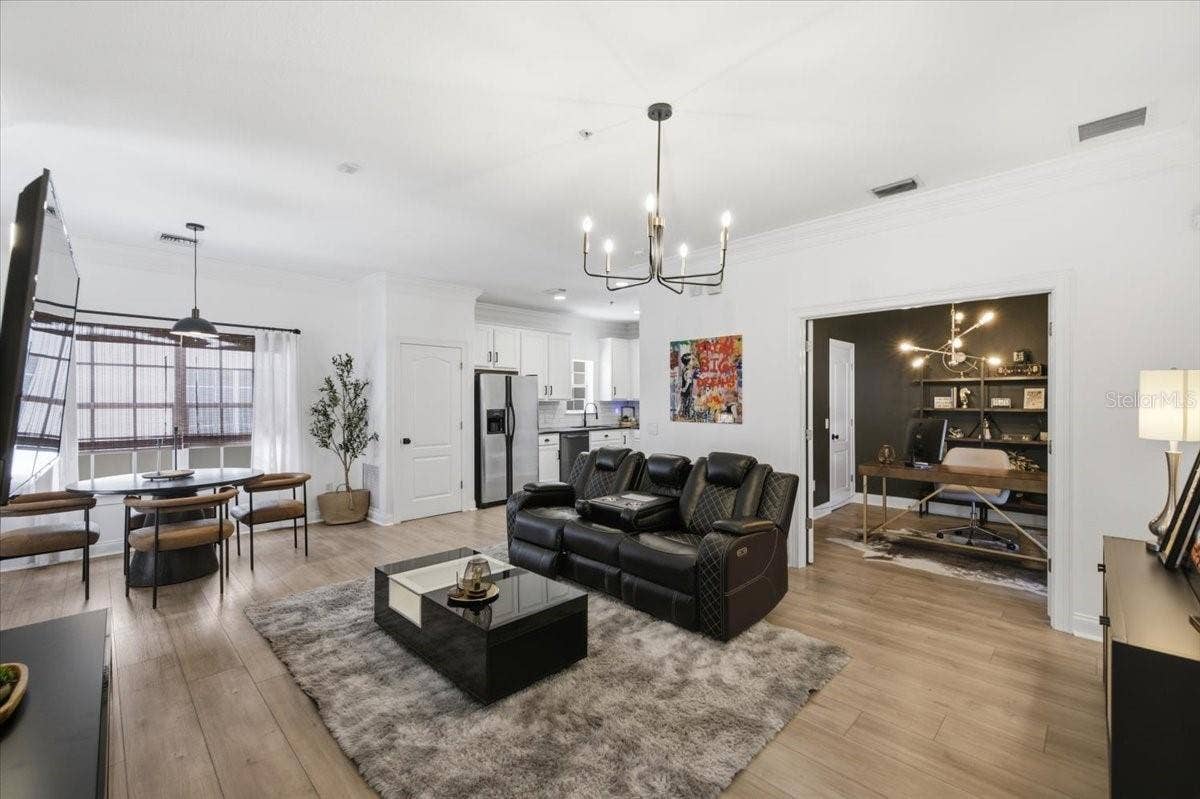 Living room updated with LVP flooring in white oak tones, with new lighting and paint!