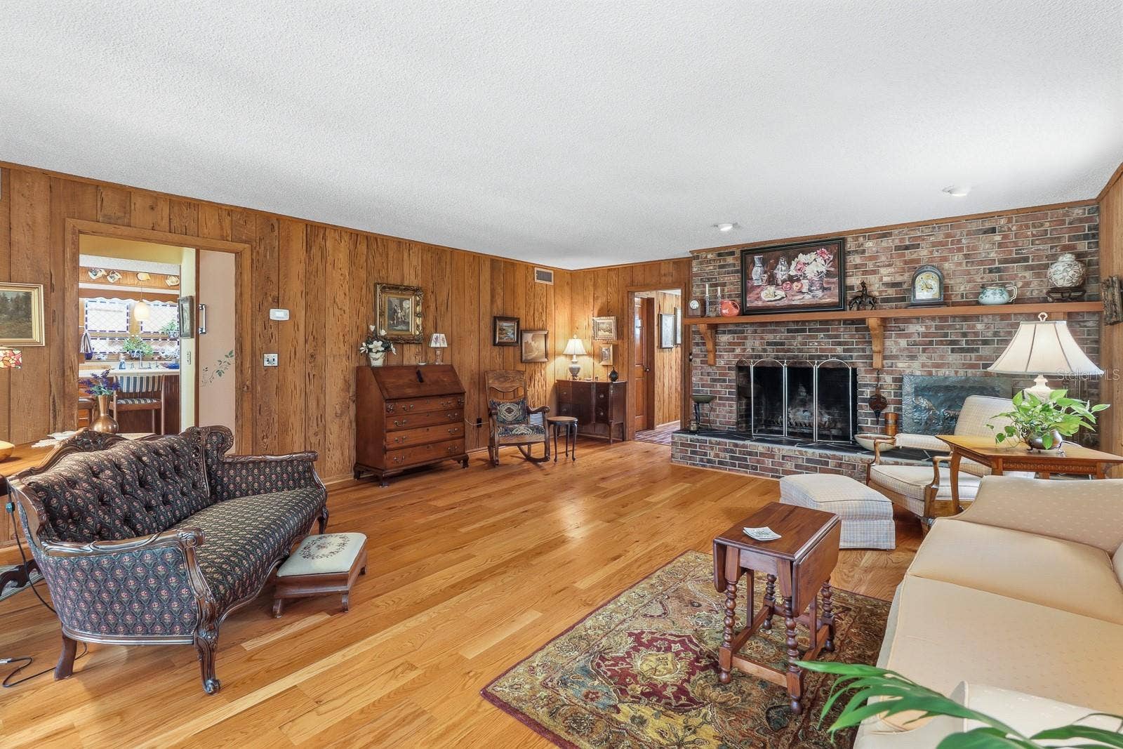 6491 SPRUCE CREEK ROAD, Port Orange, FL 32127 Formal living room with cypress walls and brick, wood burning fireplace.