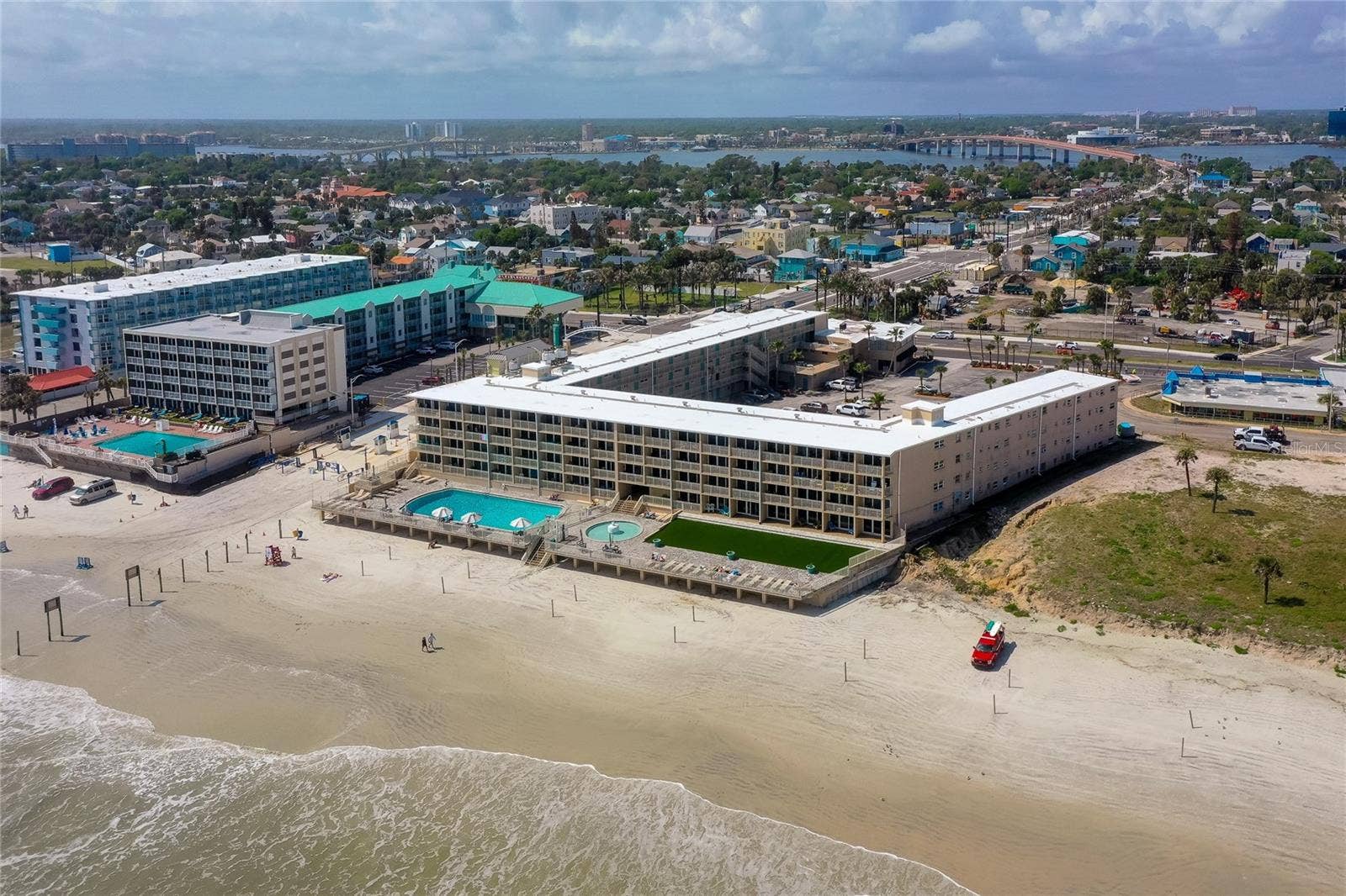 219 S ATLANTIC AVENUE, #228, Daytona Beach, FL 32118 Wide aerial view captures the full beachfront footprint of the property, with direct access to the shoreline and on-site outdoor amenities. The setting offers a true oceanfront lifestyle in the heart of Daytona Beach.