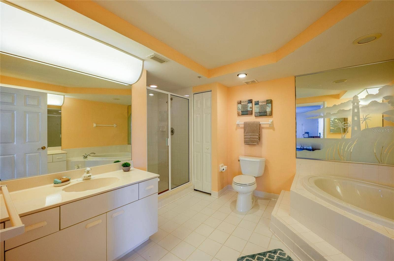 4575 S ATLANTIC AVENUE, #6101, Port Orange, FL 32127 This expansive bathroom features a wide vanity, a large soaking tub, and a separate glass-enclosed shower for a spa-like experience.