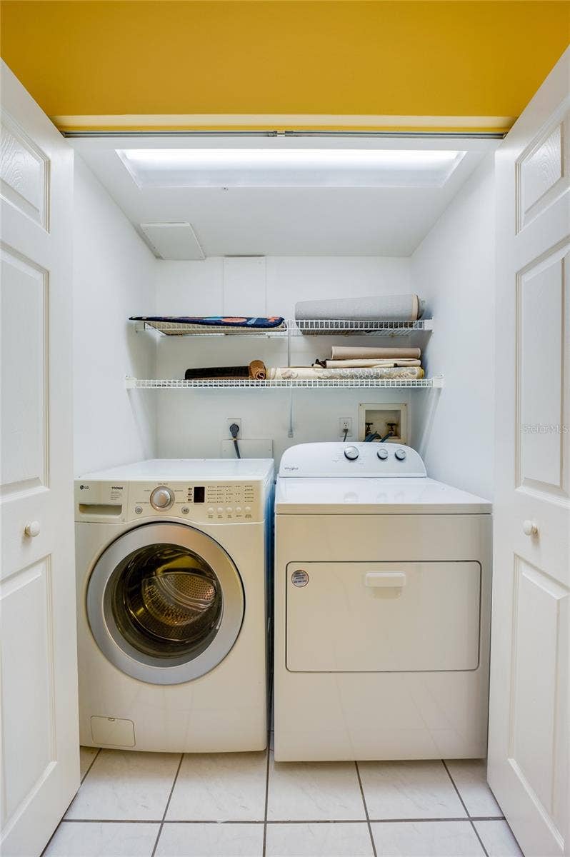 4575 S ATLANTIC AVENUE, #6101, Port Orange, FL 32127 Convenient in-unit laundry area with washer and dryer, along with additional shelving for storage.