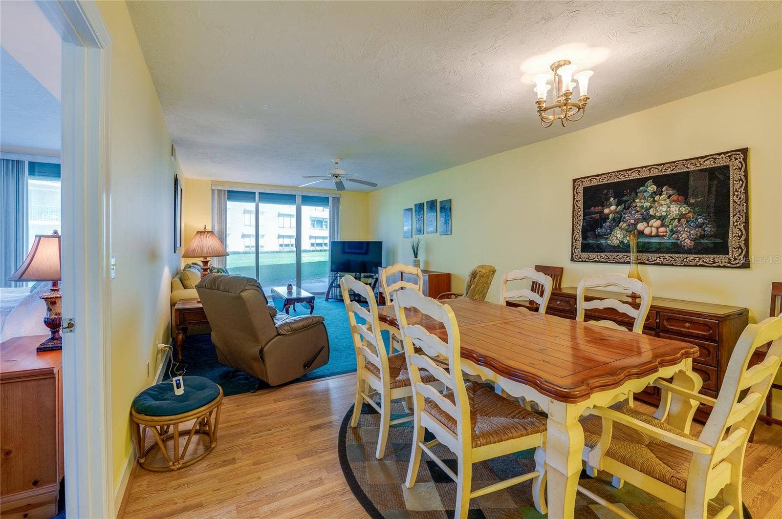 4575 S ATLANTIC AVENUE, #6101, Port Orange, FL 32127 The combined living and dining area offers a spacious layout with large sliding glass doors that bring in natural light and provide access to outdoor views, ideal for both relaxing and hosting.