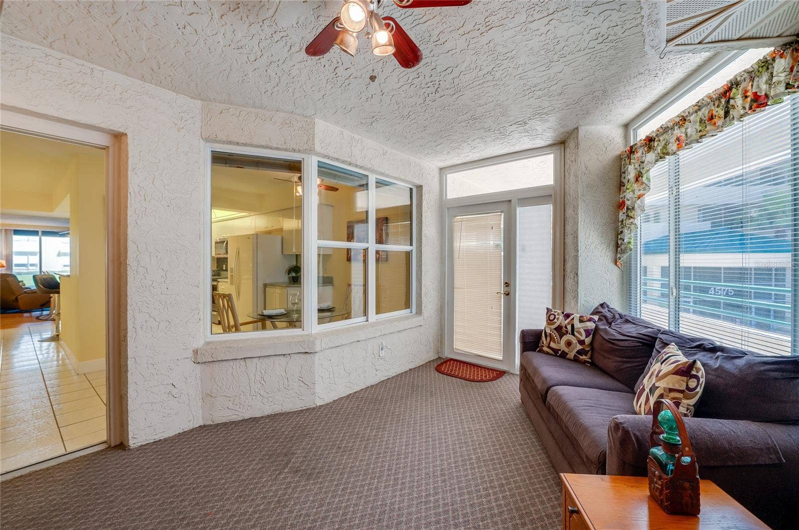 4575 S ATLANTIC AVENUE, #6101, Port Orange, FL 32127 Another angle of the sunroom highlights its versatile layout, with large windows and a view to the inside, creating a seamless indoor-outdoor living experience.