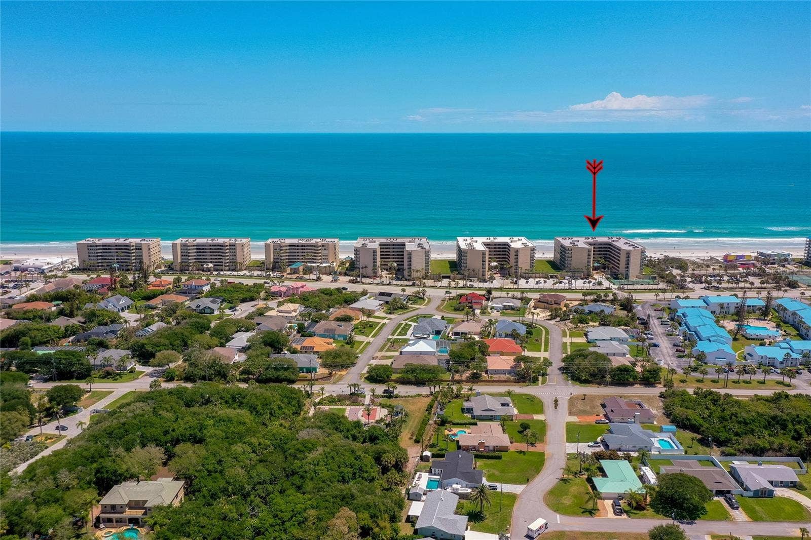 4575 S ATLANTIC AVENUE, #6101, Port Orange, FL 32127 Wide aerial capturing the surrounding oceanfront buildings and the propertys prime placement along the shoreline.