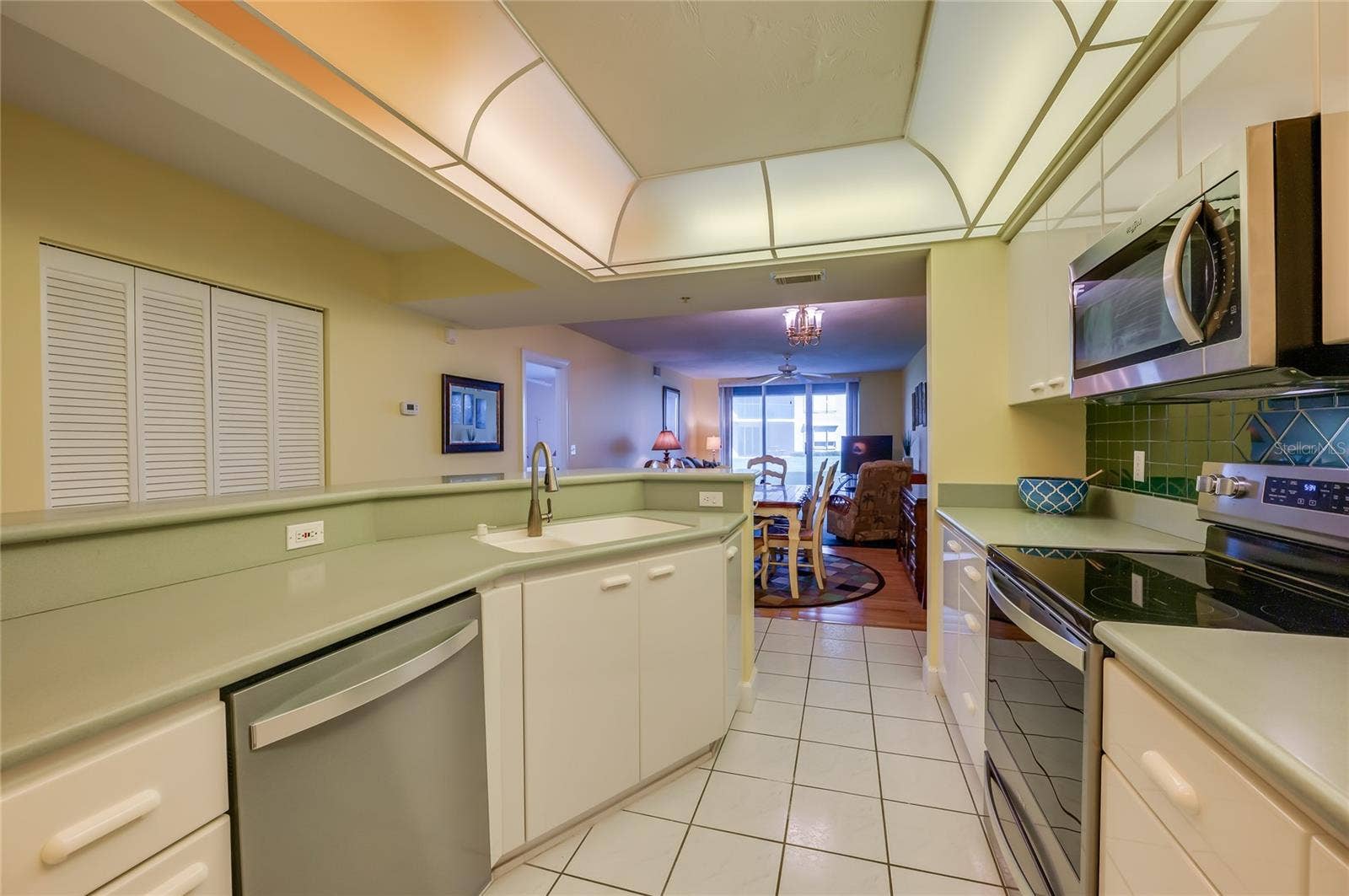 4575 S ATLANTIC AVENUE, #6101, Port Orange, FL 32127 A reverse view showcases the kitchens efficient layout, breakfast bar seating, and open connection to the main living areas.
