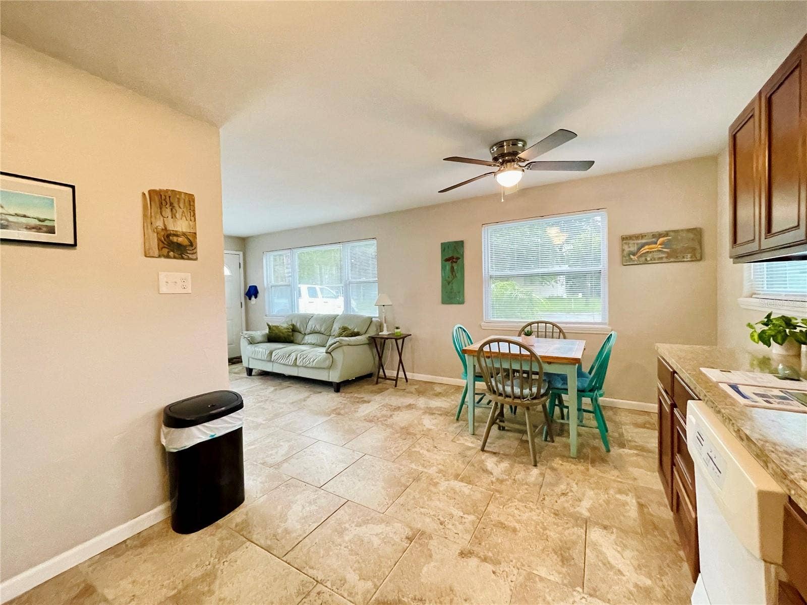 The kitchen and dining area flow naturally into the adjacent living space, creating an open, connected layout with multiple windows providing plenty of natural light.