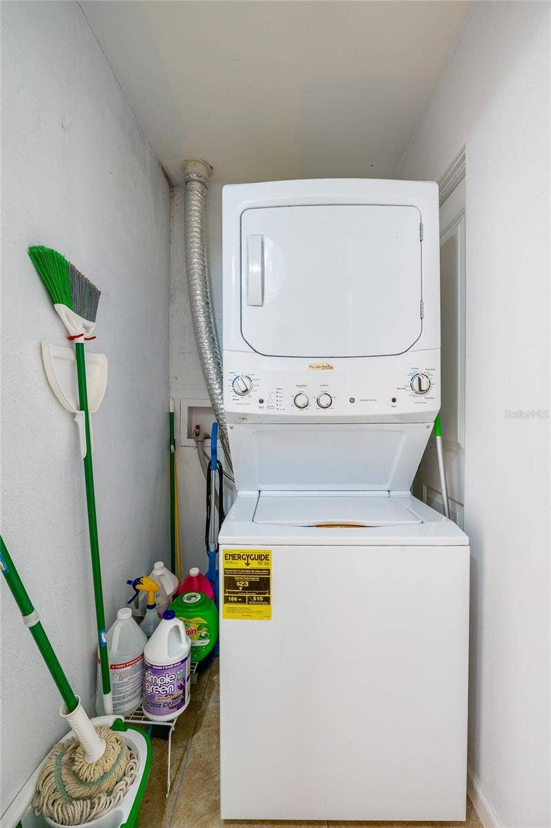 Convenient laundry niche utilizing a space-saving stacked washer and dryer unit alongside dedicated storage for household cleaning supplies.