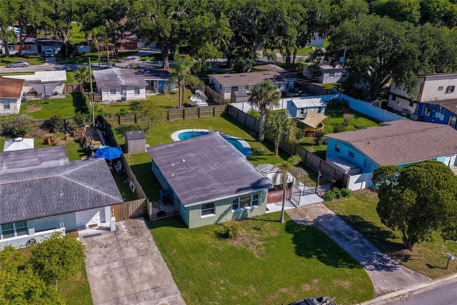 Elevated aerial view showcasing the homes layout within the neighborhood, highlighting the expansive backyard complete with an in-ground swimming pool.