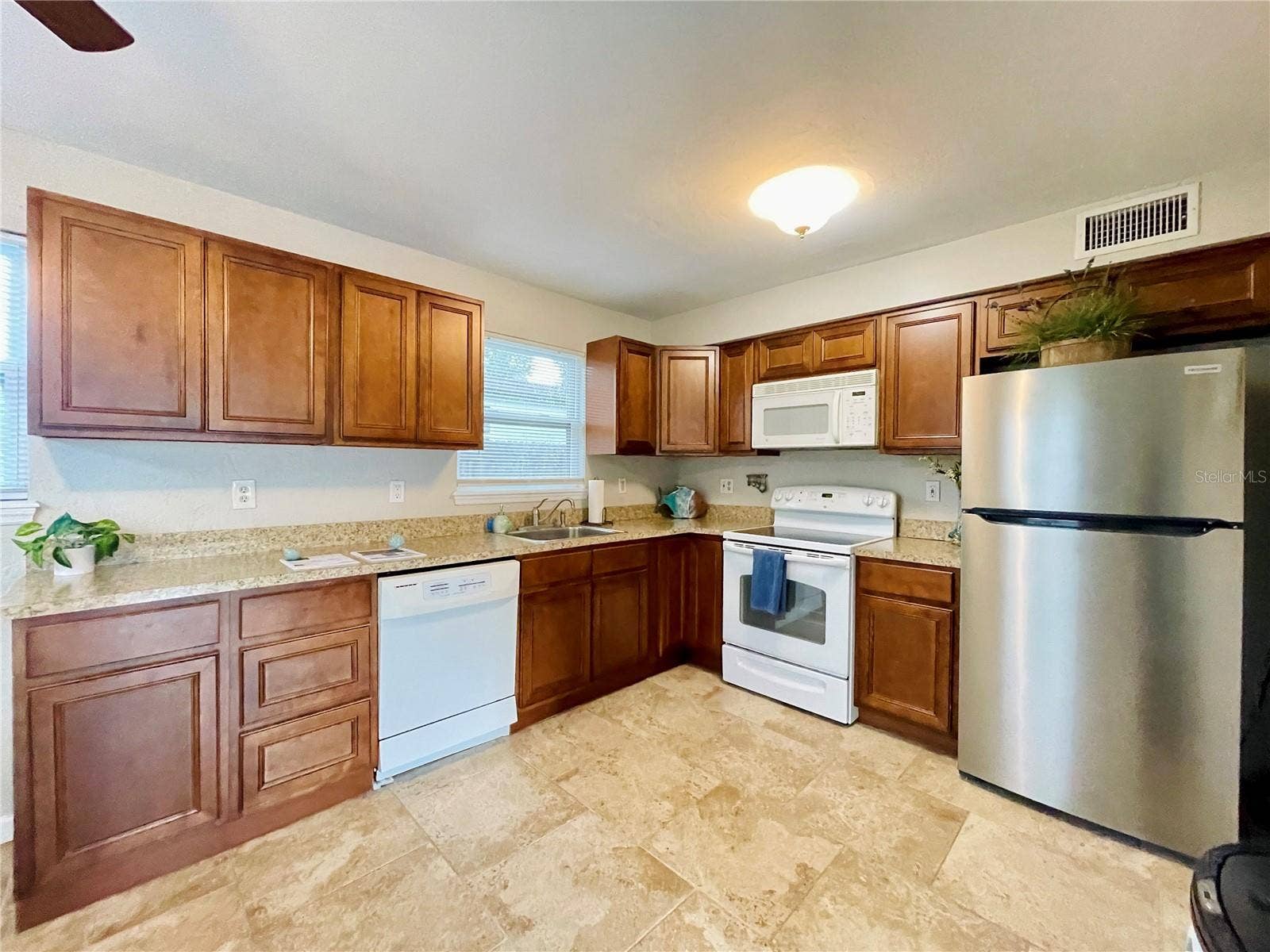 Fully equipped, efficient kitchen showcasing ample countertops and classic wood cabinets.