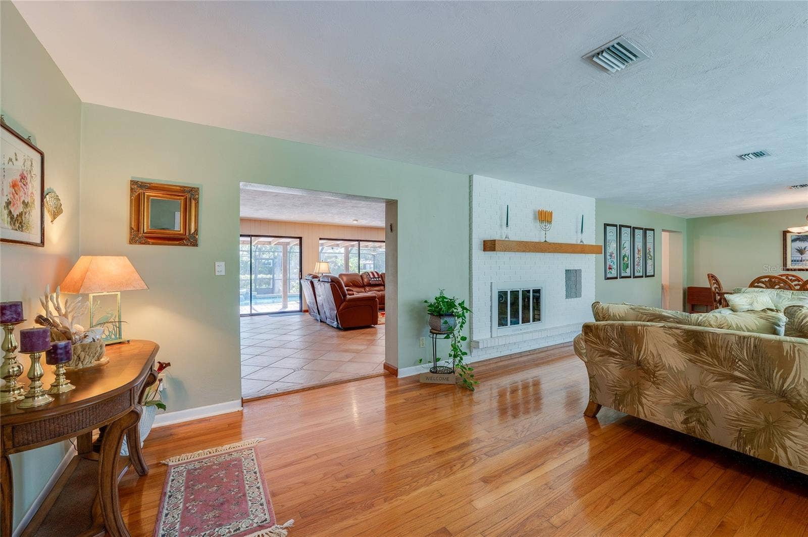 697 JOHN ANDERSON DRIVE, Ormond Beach, FL 32176 View from kitchen to family room with double-sided fireplace