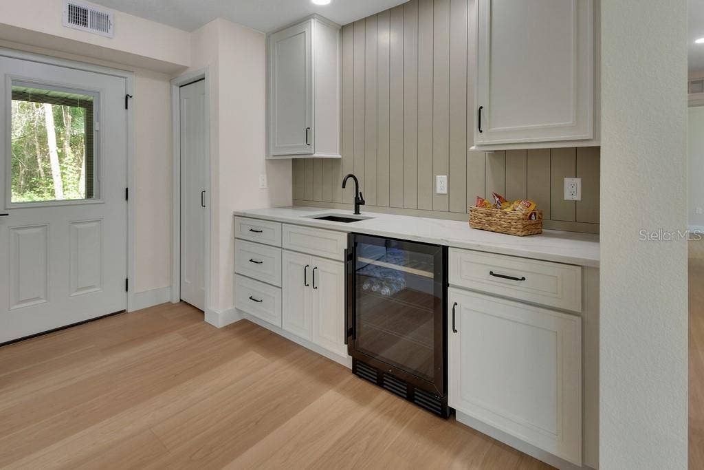 Mini fridge/wine cooler.Beautiful cabinetry. Coat closet to the left.