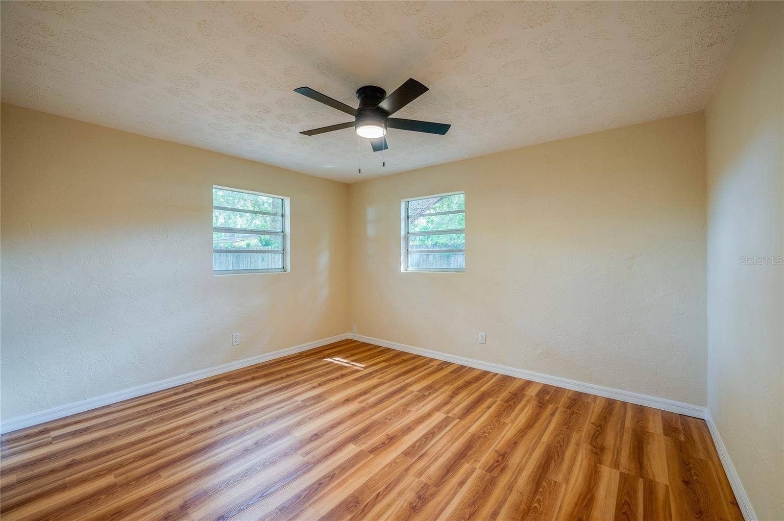 1220 LEON LANE, Daytona Beach, FL 32117 Spacious bedroom with ample natural light, ceiling fan, and a neutral color palette ready for your personal touch.