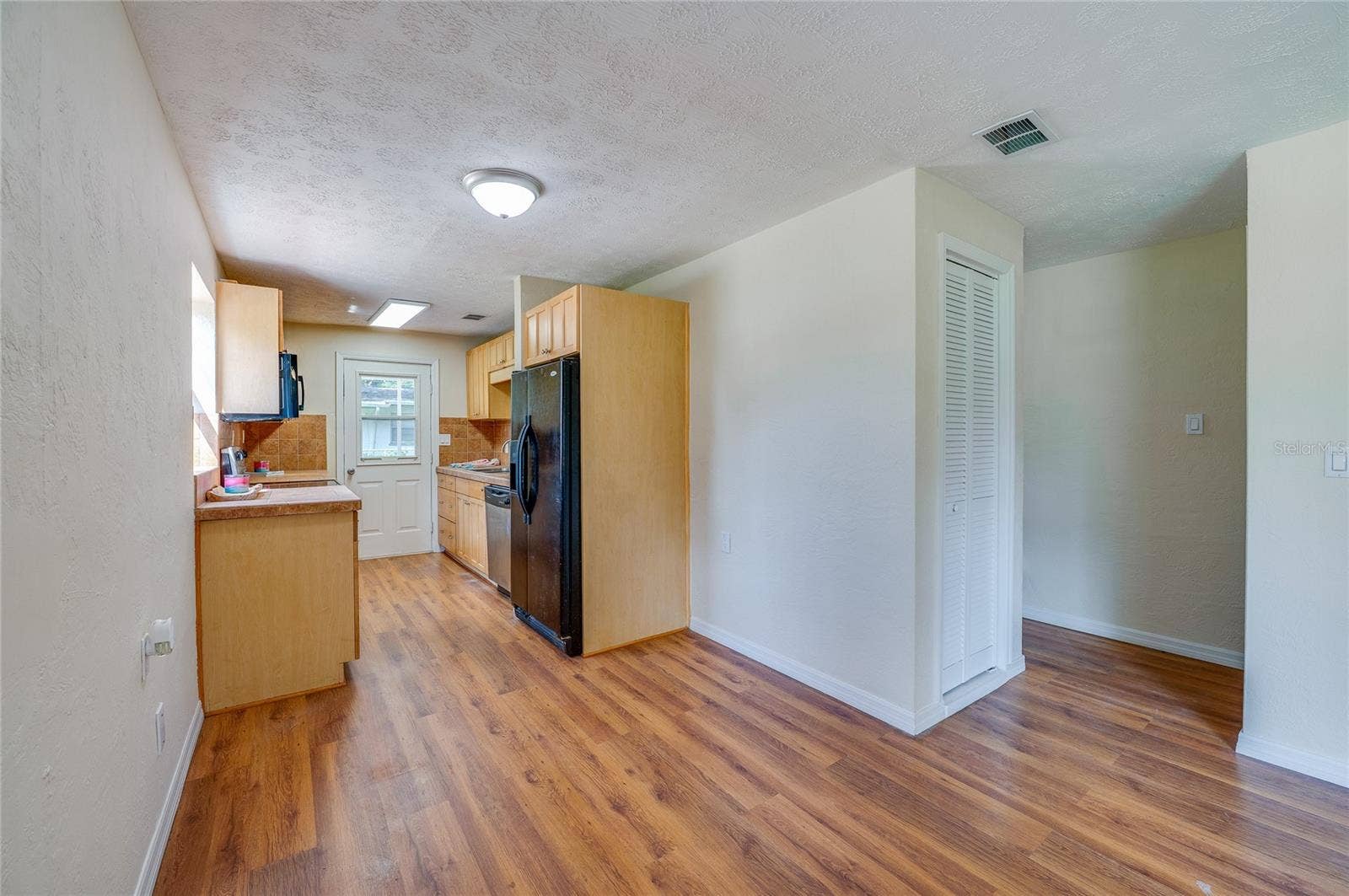 1220 LEON LANE, Daytona Beach, FL 32117 Open-concept living area flows seamlessly into the kitchen, creating a functional layout with abundant natural light.