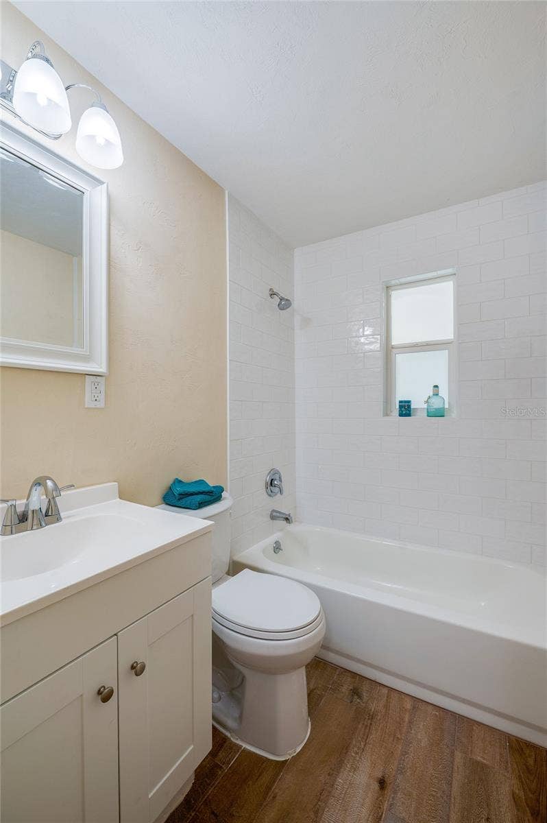 1220 LEON LANE, Daytona Beach, FL 32117 Updated full bathroom with a modern vanity, tub/shower combination, and classic subway tile surround for a clean, timeless look.