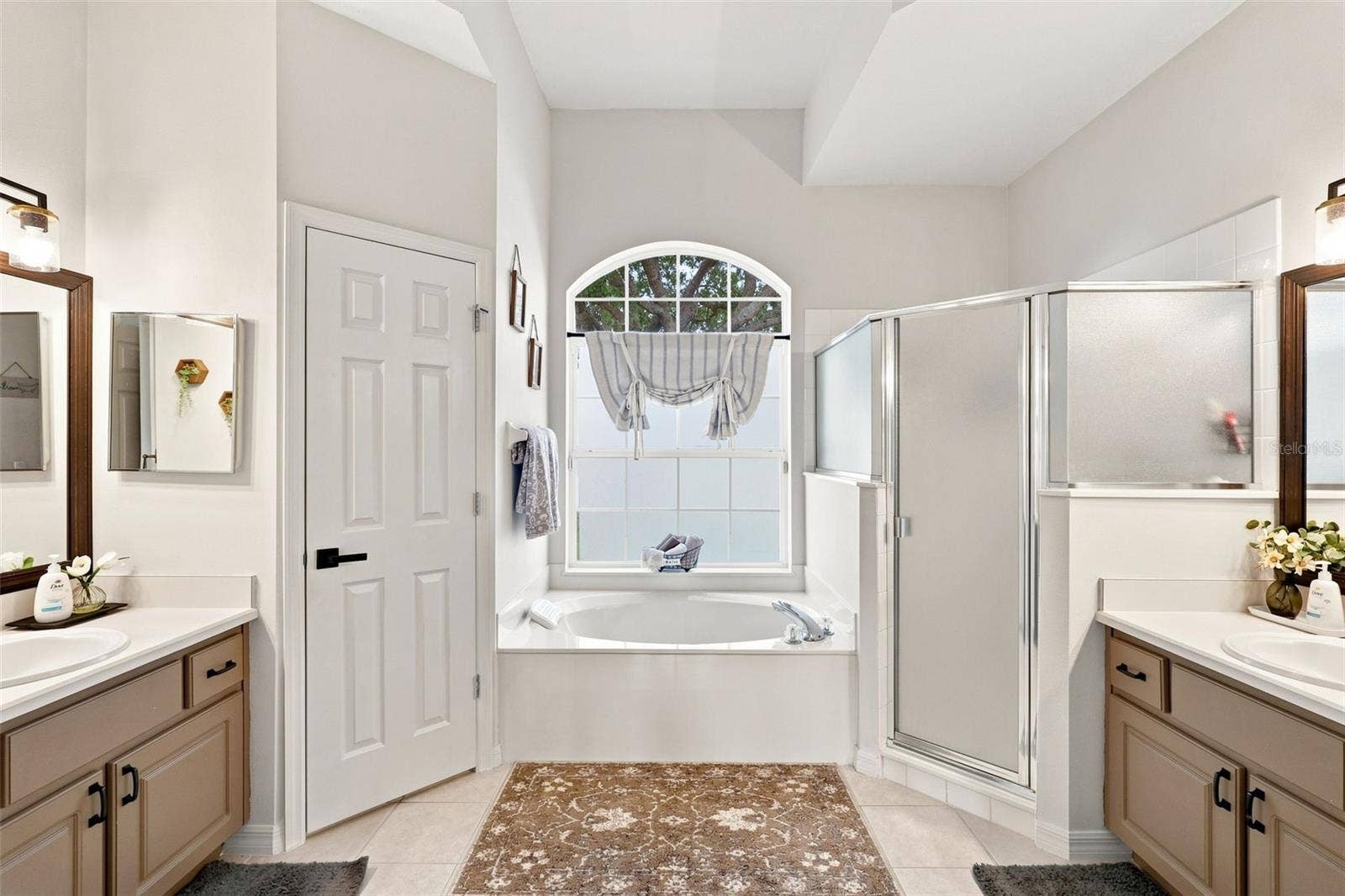Dual vanity bathroom with his & hers closet space inside primary bedroom.