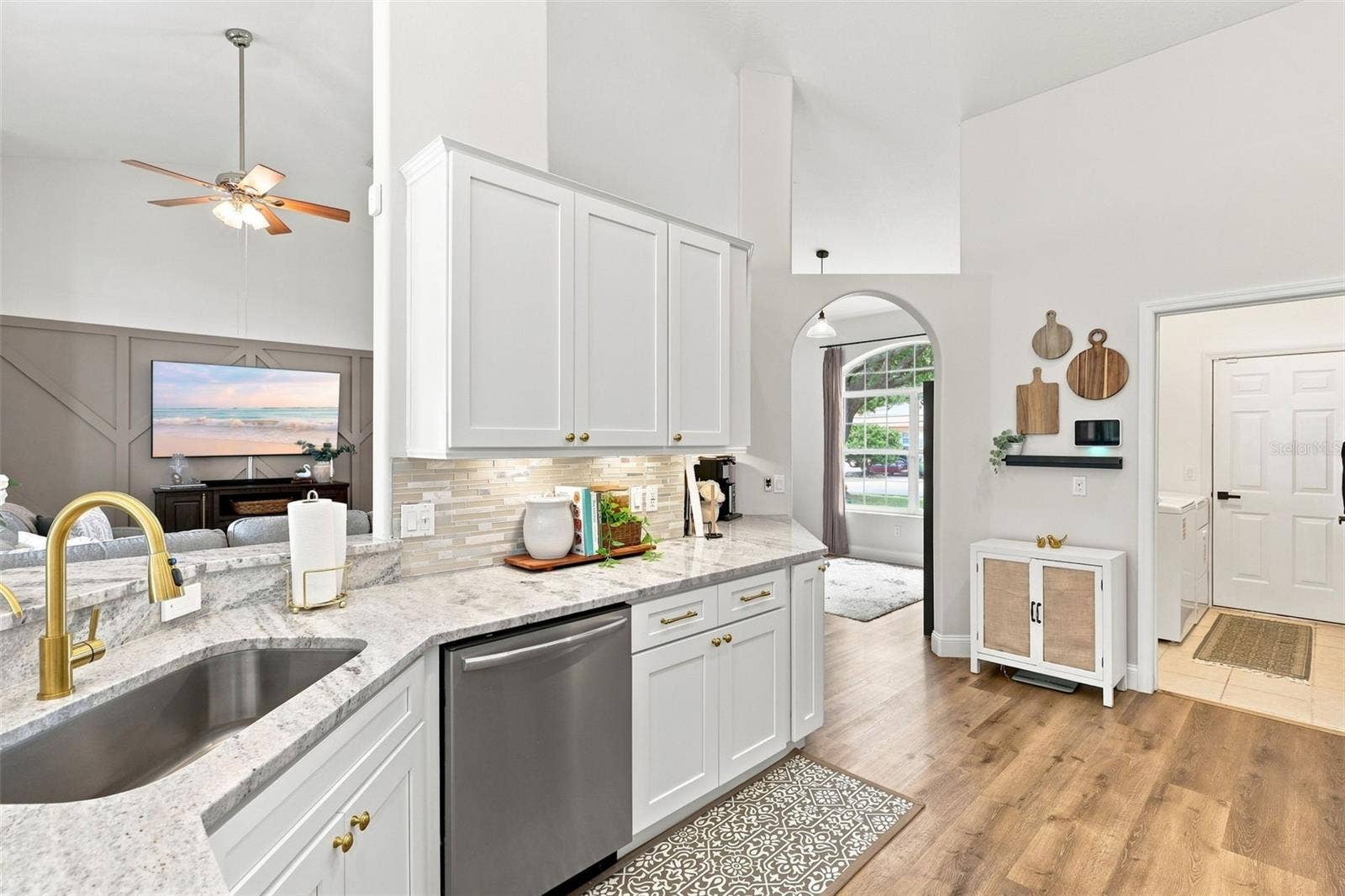 Remodeled kitchen towards indoor laundry room and garage at right. Open to main living area at left.