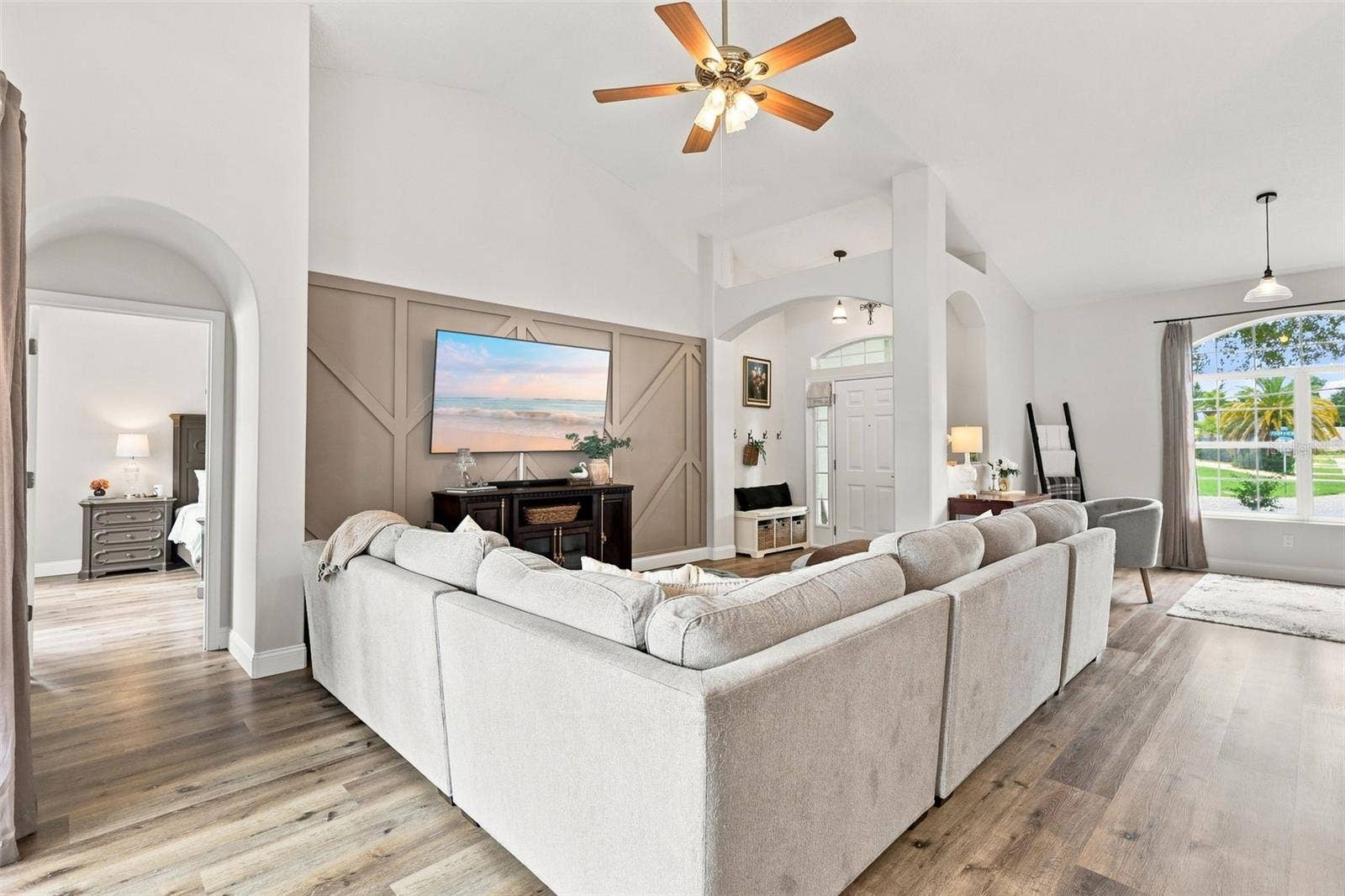 Main living area with primary bedroom suite at left. The soaring ceilings make this home feel even larger than it is.