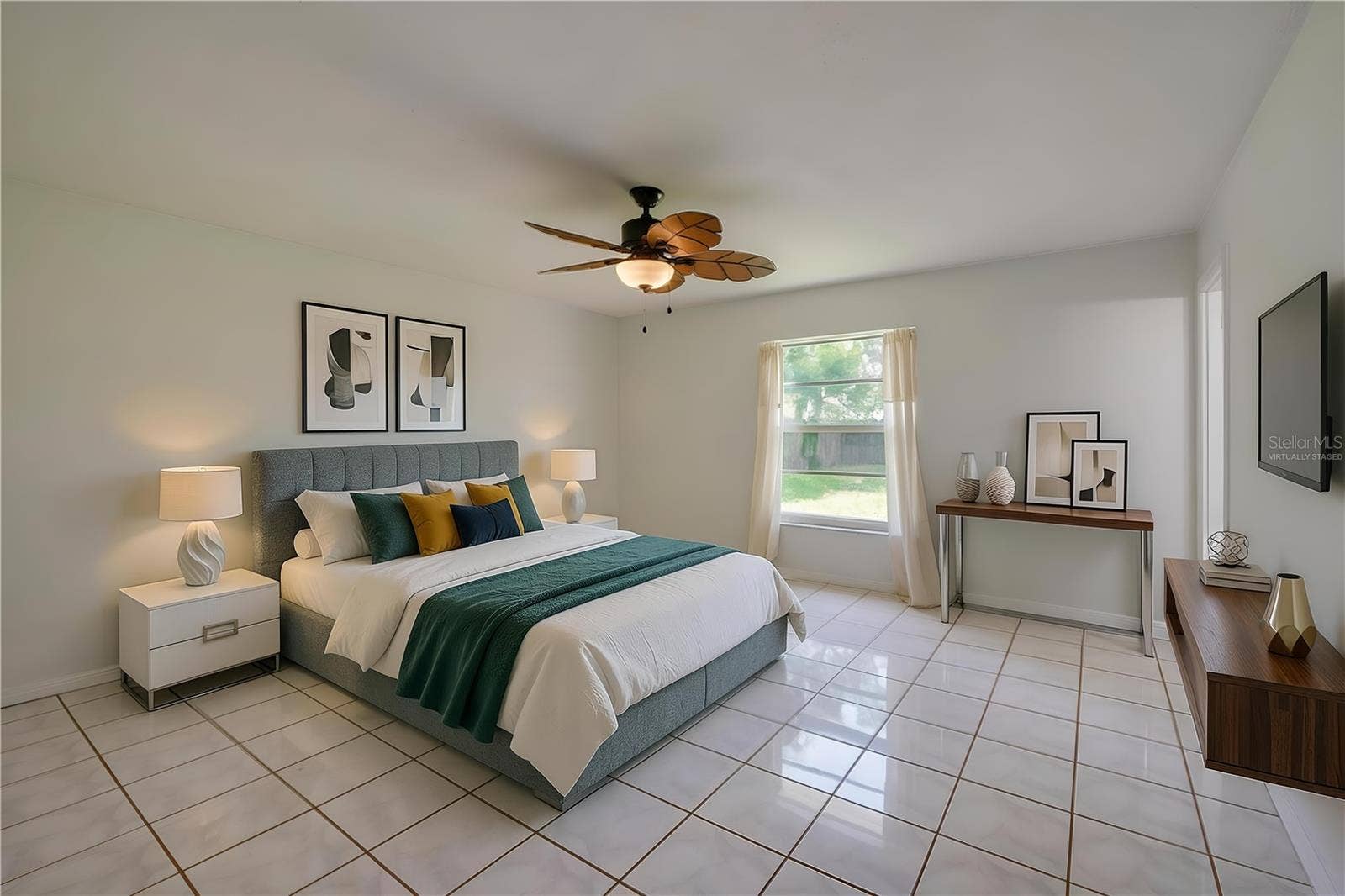 156 SPRINGWOOD DRIVE, Daytona Beach, FL 32119 Virtually Staged. Generous primary bedroom area featuring glossy tiled flooring, neutral walls, and a tropical-style wooden ceiling fan. A single window brings natural light into the open space.