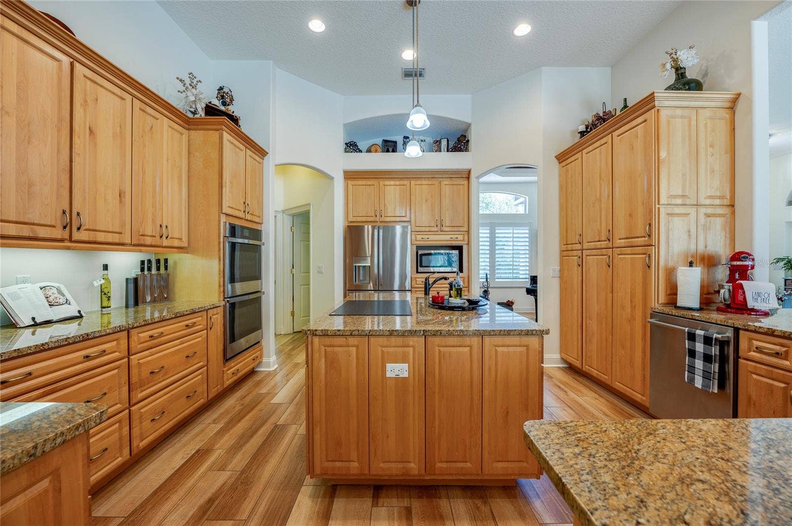 25 REMINGTON ROAD, Ormond Beach, FL 32174 Spacious chef's kitchen centered around a multi-functional island with granite countertops, integrated appliances, and a built-in cooktop.