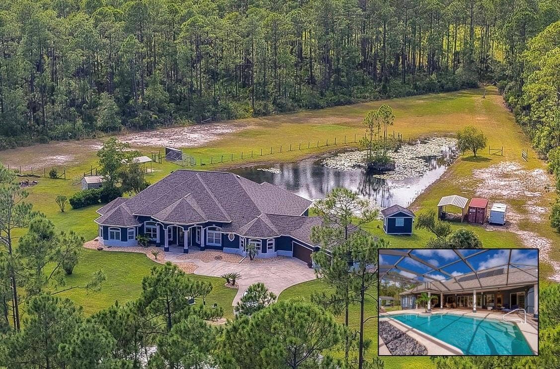 25 REMINGTON ROAD, Ormond Beach, FL 32174 Expansive private home surrounded by dense green forest, a scenic pond, and a long paved driveway.