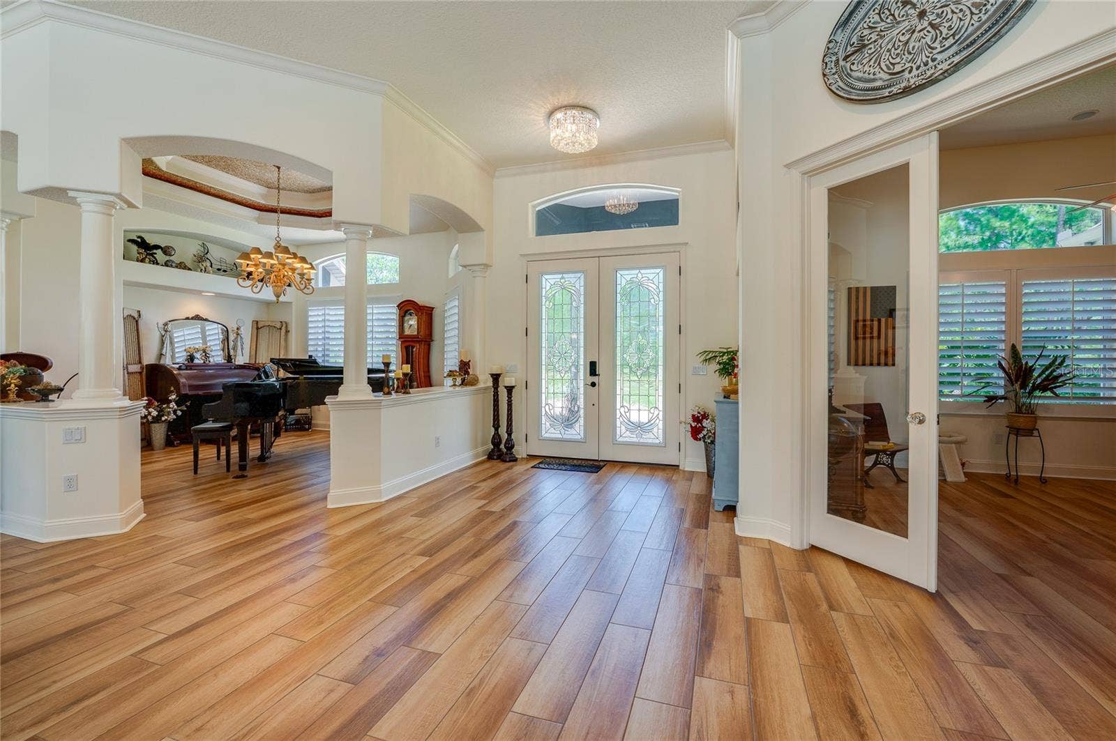 25 REMINGTON ROAD, Ormond Beach, FL 32174 Welcoming grand entryway featuring double glass front doors, rich tile flooring, recessed lighting, and arched architectural openings.