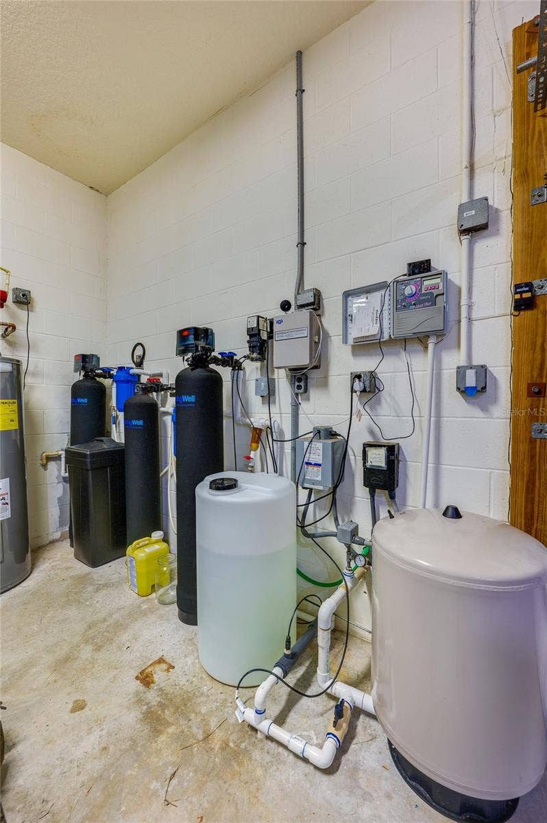 25 REMINGTON ROAD, Ormond Beach, FL 32174 Dedicated mechanical and utility space housing a whole-home water treatment system, water heater, and filtration tanks.