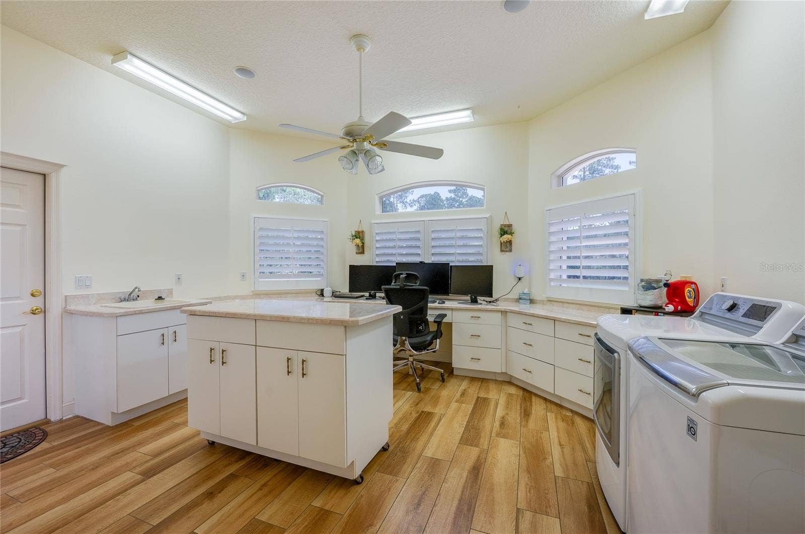 25 REMINGTON ROAD, Ormond Beach, FL 32174 Spacious multi-purpose utility room equipped with tile flooring, extensive built-in cabinetry, an island, and in-unit laundry appliances.