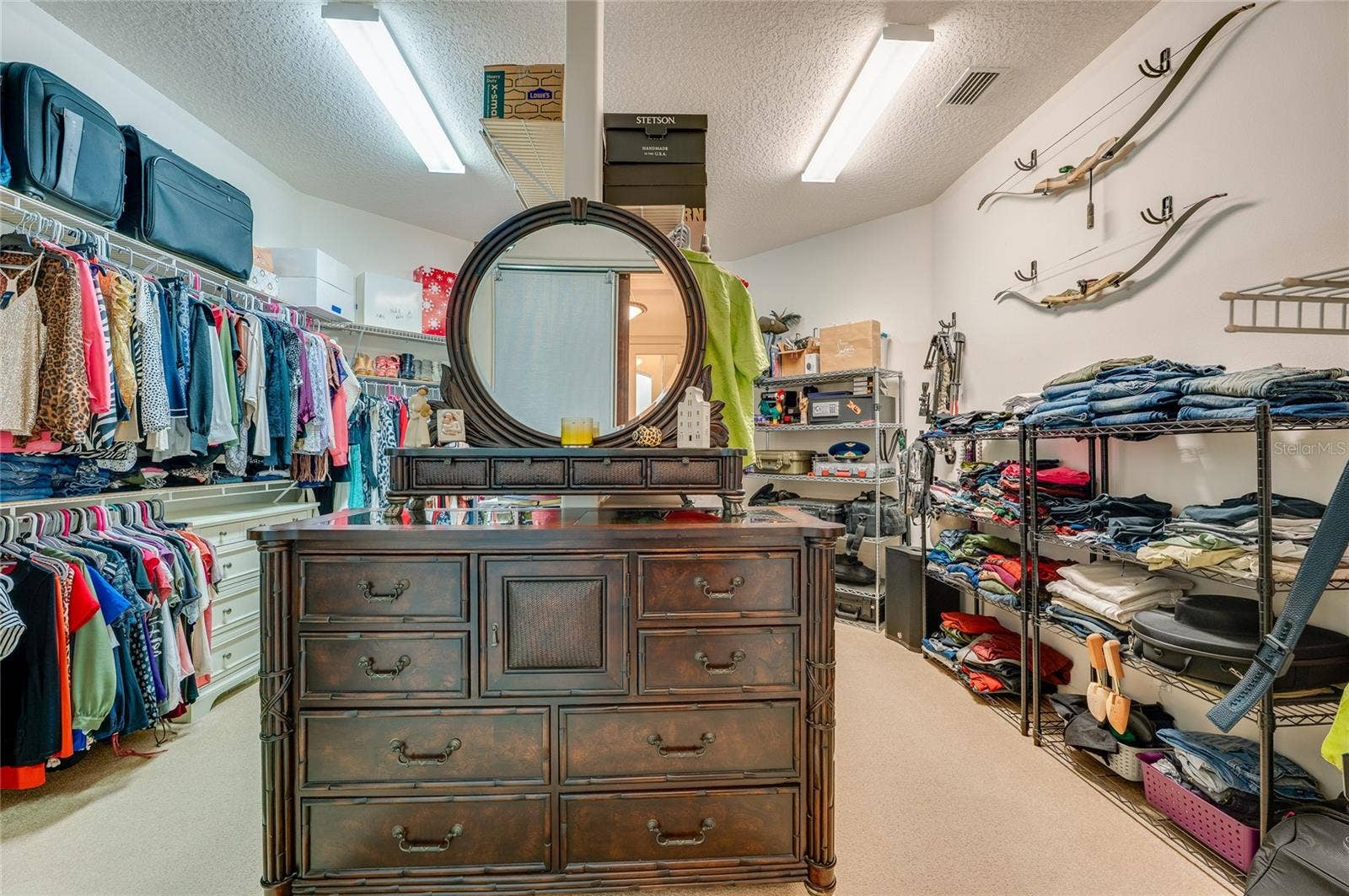 25 REMINGTON ROAD, Ormond Beach, FL 32174 Generously sized walk-in closet featuring extensive built-in wire shelving, overhead lighting, and ample clothing storage space.