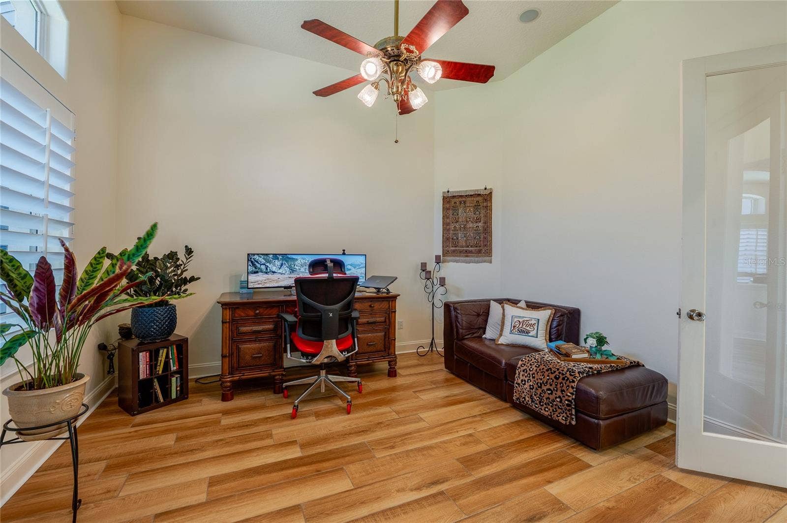 25 REMINGTON ROAD, Ormond Beach, FL 32174 Dedicated home office setup with tile flooring, high ceilings, a ceiling fan, and plantation shutters.