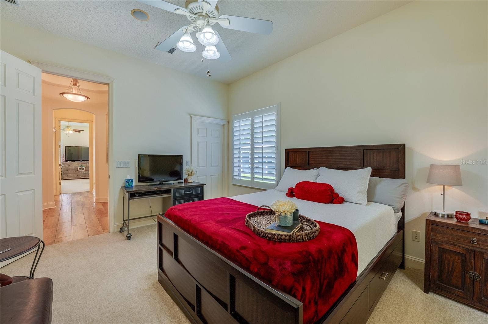 25 REMINGTON ROAD, Ormond Beach, FL 32174 Comfortable room centered around plantation-shuttered windows and neutral carpeted floors. An open view leads into an adjacent hallway.