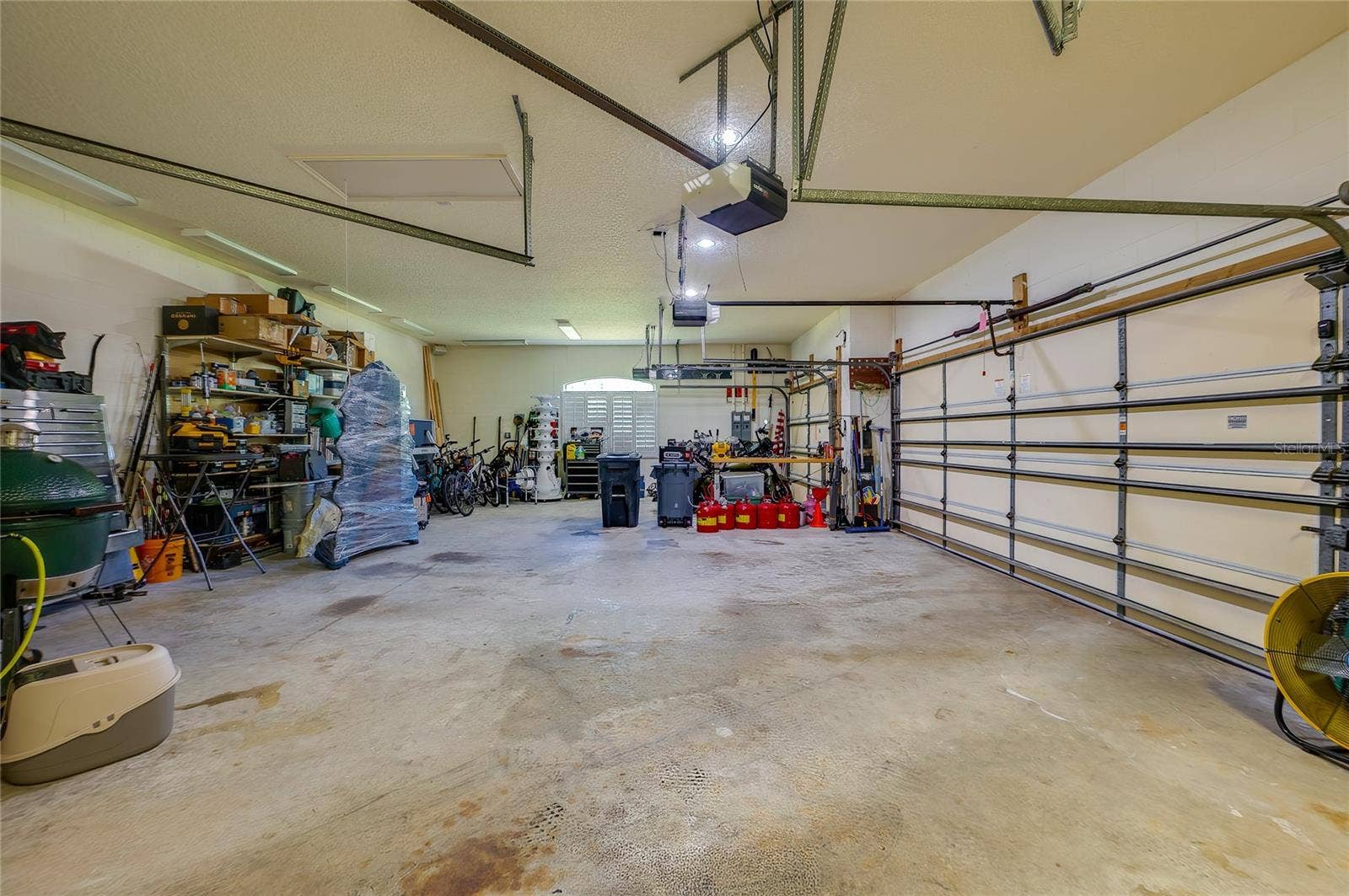 25 REMINGTON ROAD, Ormond Beach, FL 32174 Expansive multi-car garage featuring concrete floors, overhead garage door tracks, high ceilings, and ample storage space along the side wall.
