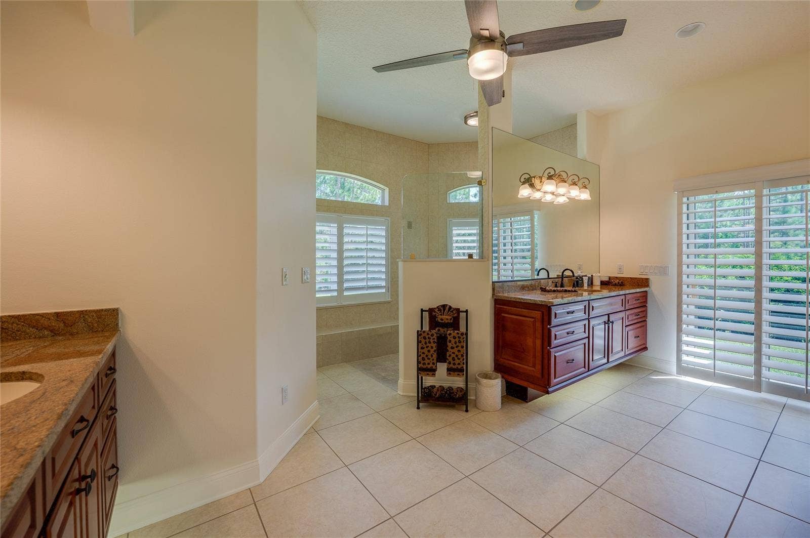 25 REMINGTON ROAD, Ormond Beach, FL 32174 Expansive ensuite bathroom complete with tile flooring, dual sink vanities, and wall-mounted vanity lighting.