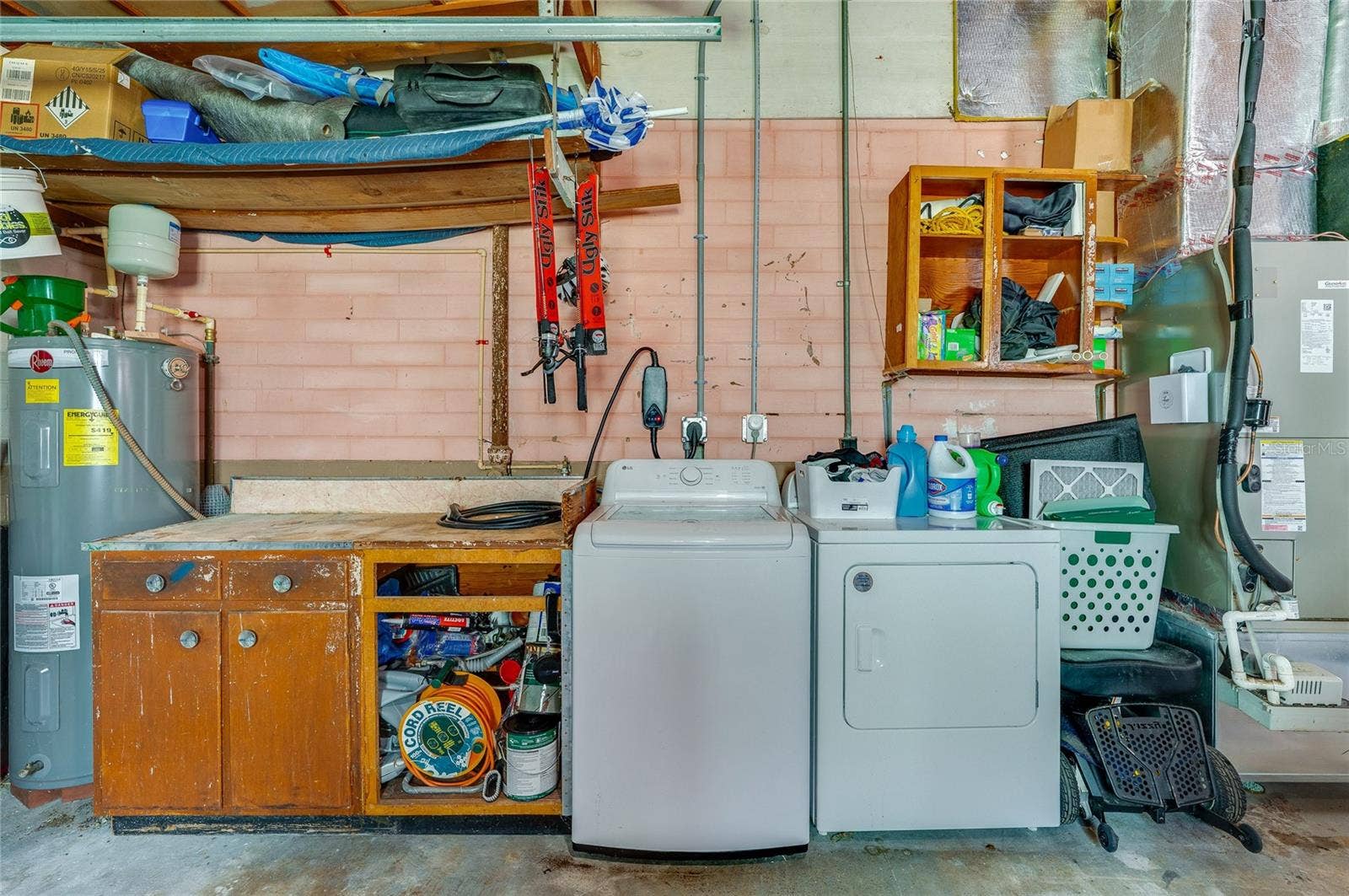 348 WOODLAND AVENUE, Daytona Beach, FL 32118 Dedicated utility station in the garage offering a washer and dryer alongside a built-in workbench and open storage shelves.