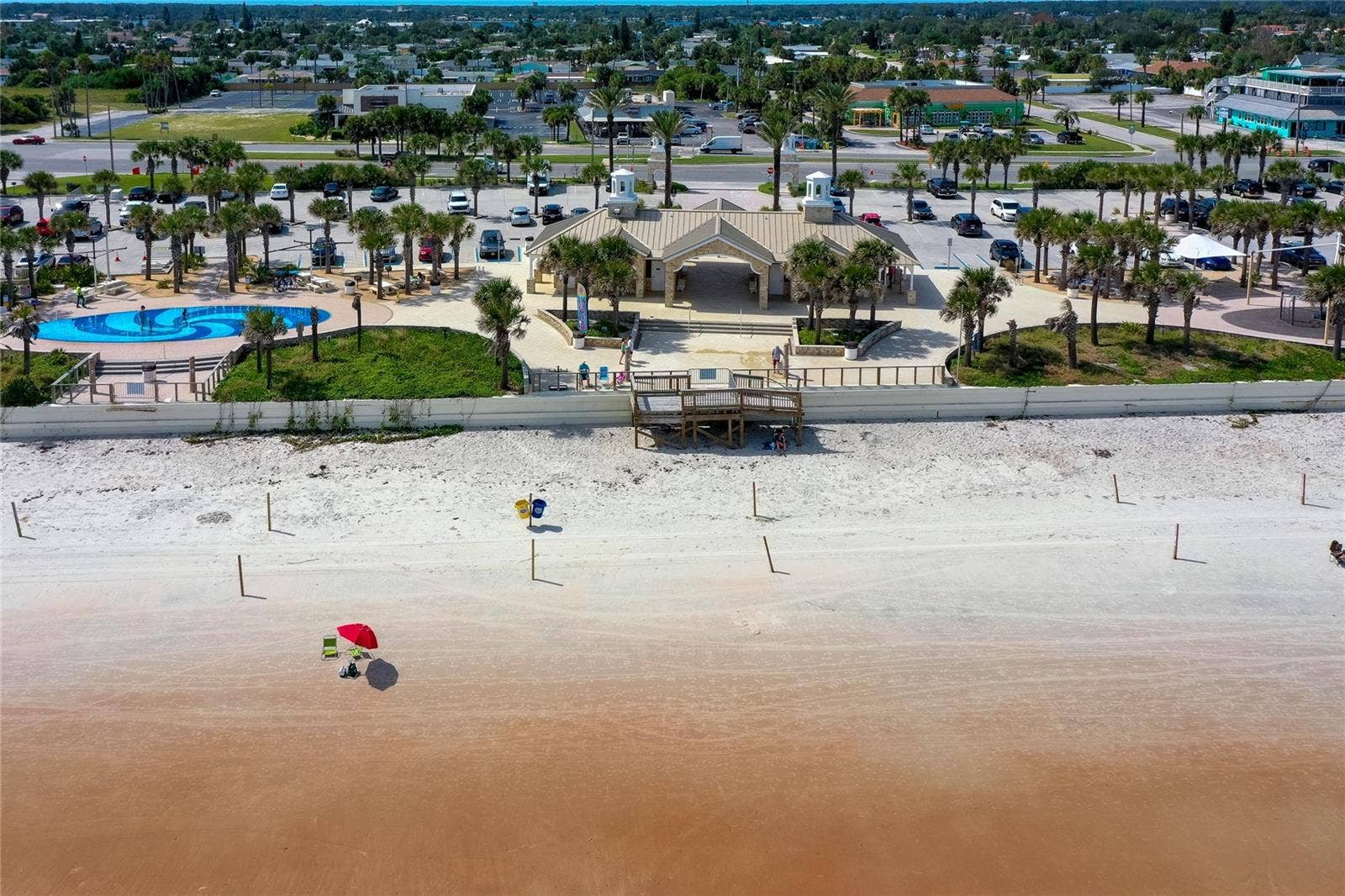 348 WOODLAND AVENUE, Daytona Beach, FL 32118 Aerial view showcases nearby Andy Romano Beachfront Park with direct Atlantic Ocean access, beachfront facilities, palm-lined grounds, and convenient parking.