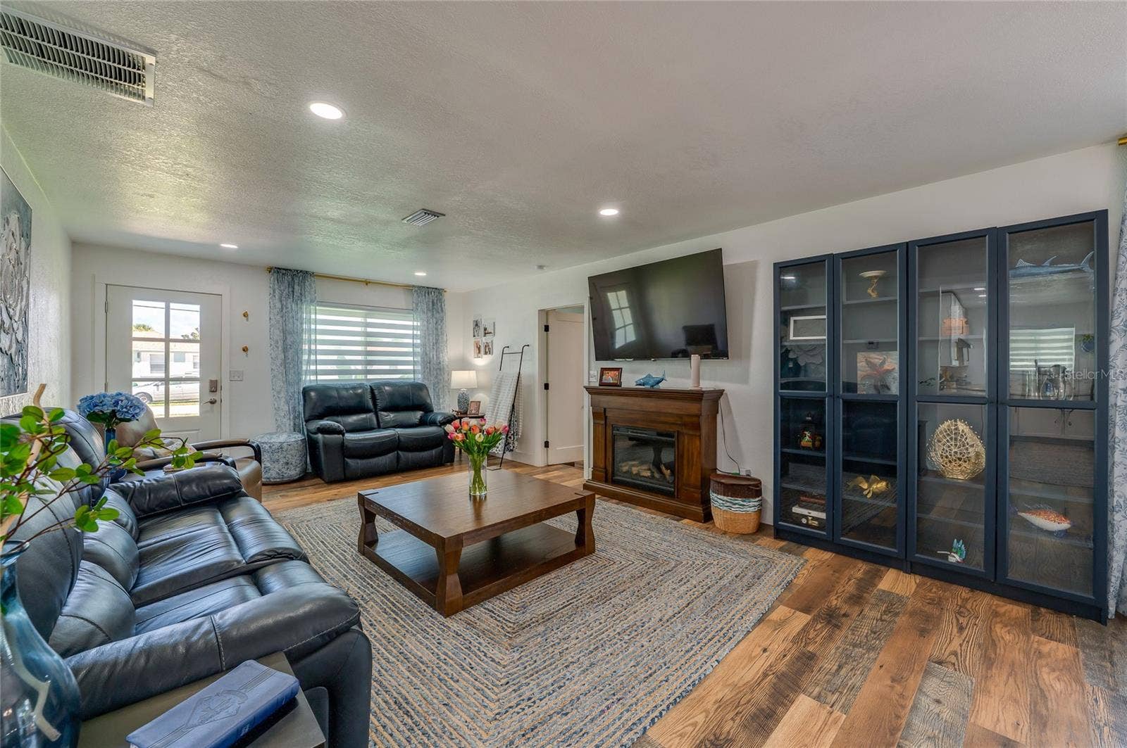 348 WOODLAND AVENUE, Daytona Beach, FL 32118 Generously sized main living space featuring rich LVP flooring under soft recessed lighting.
