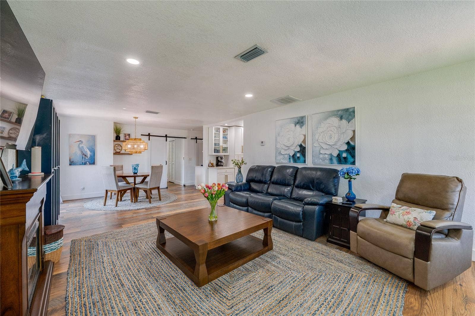 348 WOODLAND AVENUE, Daytona Beach, FL 32118 Bright and inviting interior layout featuring seamless flow between the living space and dining area, accented by a sliding barn door.