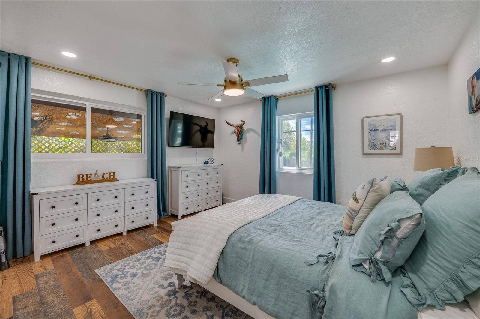 348 WOODLAND AVENUE, Daytona Beach, FL 32118 Light-filled bedroom featuring double windows, LVP flooring, and recessed ceiling lighting with a matching ceiling fan.