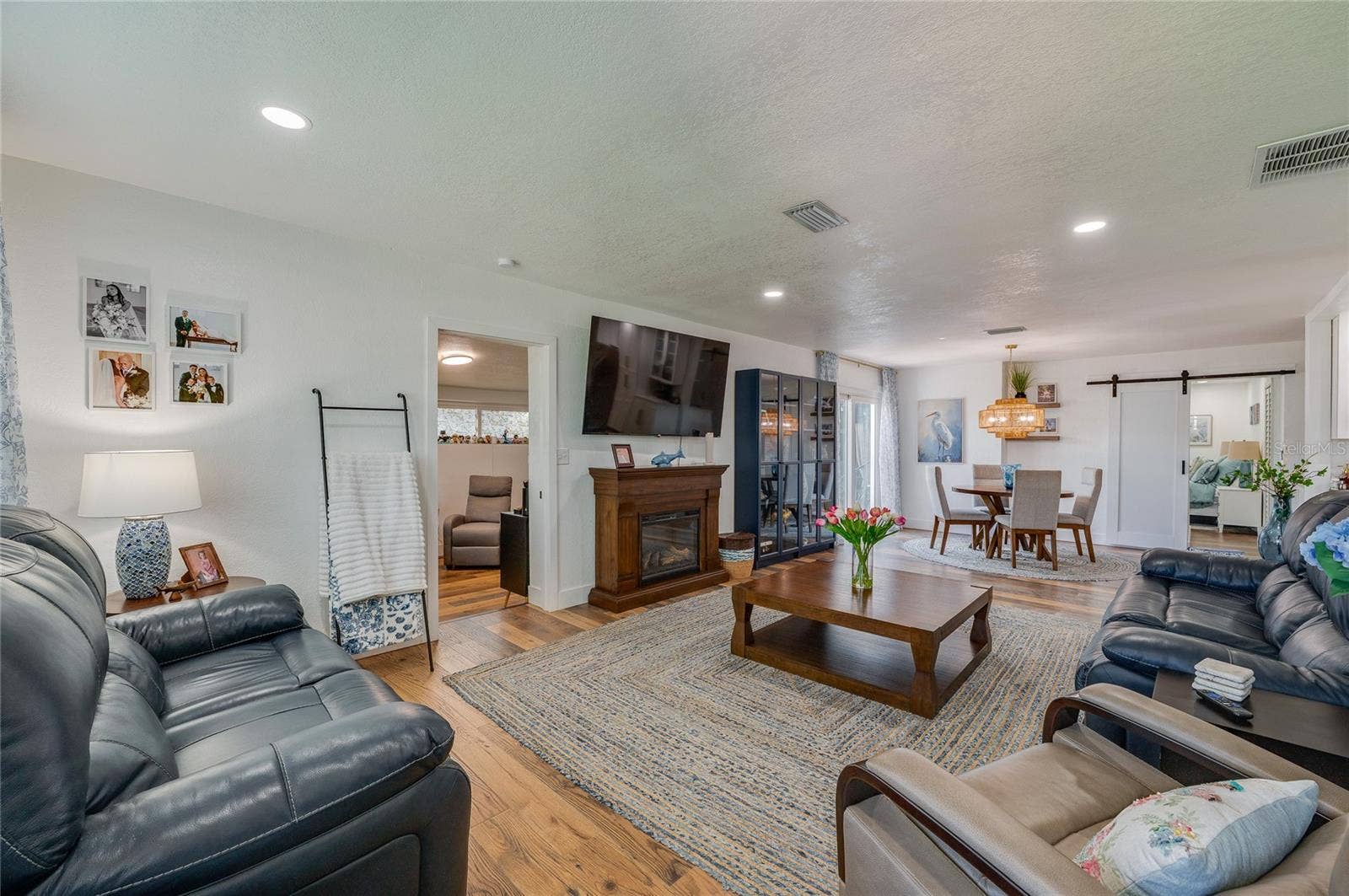 348 WOODLAND AVENUE, Daytona Beach, FL 32118 Spacious open-concept living area with warm LVP flooring, recessed lighting.